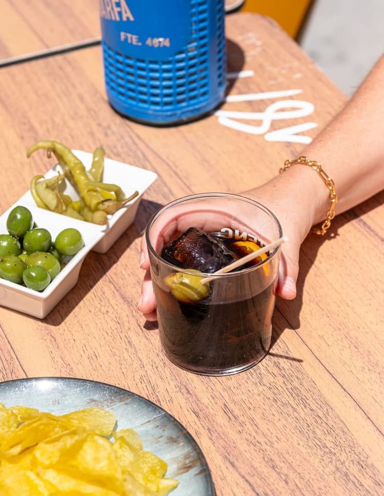 Un cocktail avec des glaçons et une olive.
